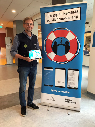 Sådan kan du kende IT-hjælperne  De frivillige IT-hjælpere kan kendes på deres mørkeblå veste påtrykt ”Frivillig”, et badge med teksten ”IT-hjælper” og et identitetskort med ”Frivillig”.