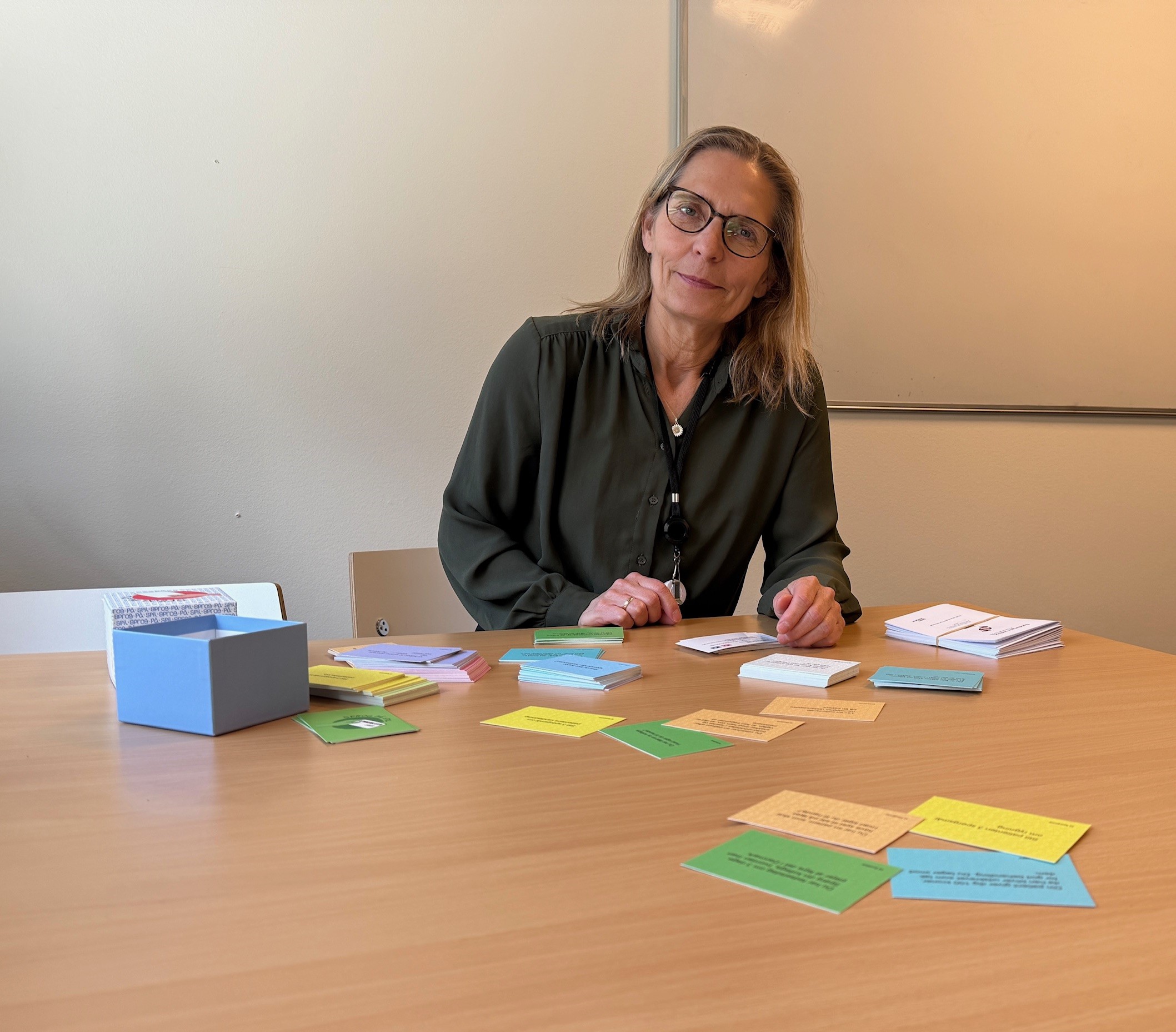 Sproglærer Jane Christensen med samtalekortene, hun bruger i sprogundervisningen.