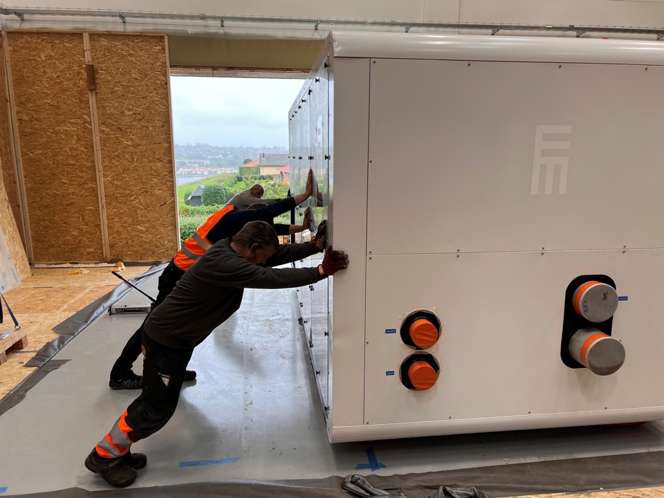 Varmepumpen skubbes på plads af kranfolkene