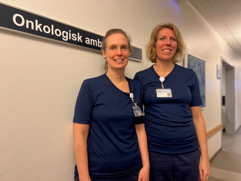 Mette og Joan, de to initiativtagere står på gangen i deres sygeplejerske uniform
