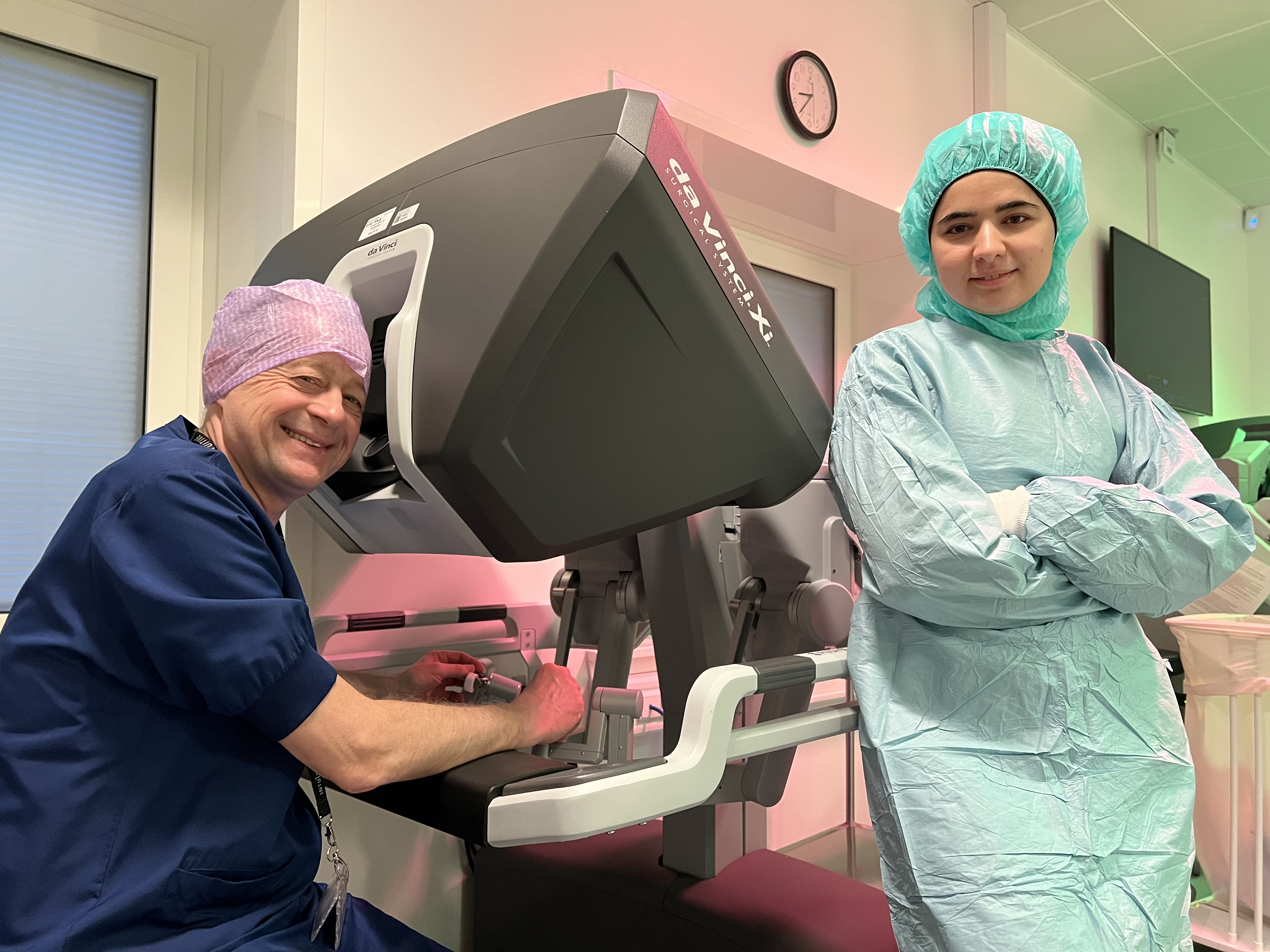 Klinisk professor i robotkirurgi Michael Festersen er selv en af operatørerne på operationsrobotten. Ved siden af ham er det HU-læge Ayat Allah Alnabhan, der i sin kandidatafhandling trak data på de mange brokoperationer på Sygehus Sønderjylland i perioden 2017-2019. Det er disse data, der ligger til grund for de to Ph.d.-studerendes analyse og konklusioner, der er blevet publiceret i tidsskriftet Hernia. Kristian Als Nielsen og Alexandros Valsamidis kunne dog ikke være til stede, da billedet blev taget.