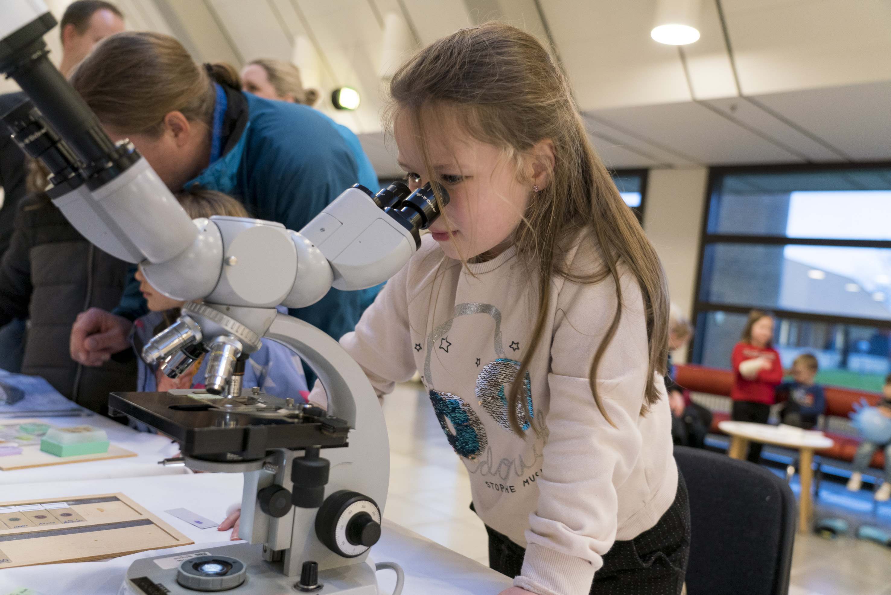 Pige kigger i mikroskop.