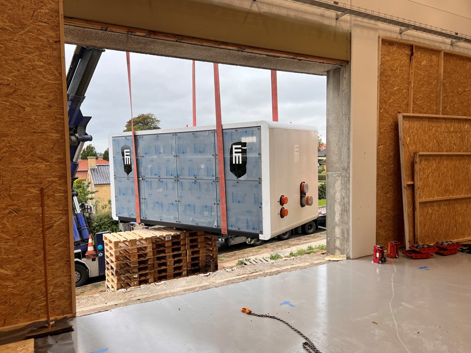 Varmepumpe på vej gennem stort hul i mur