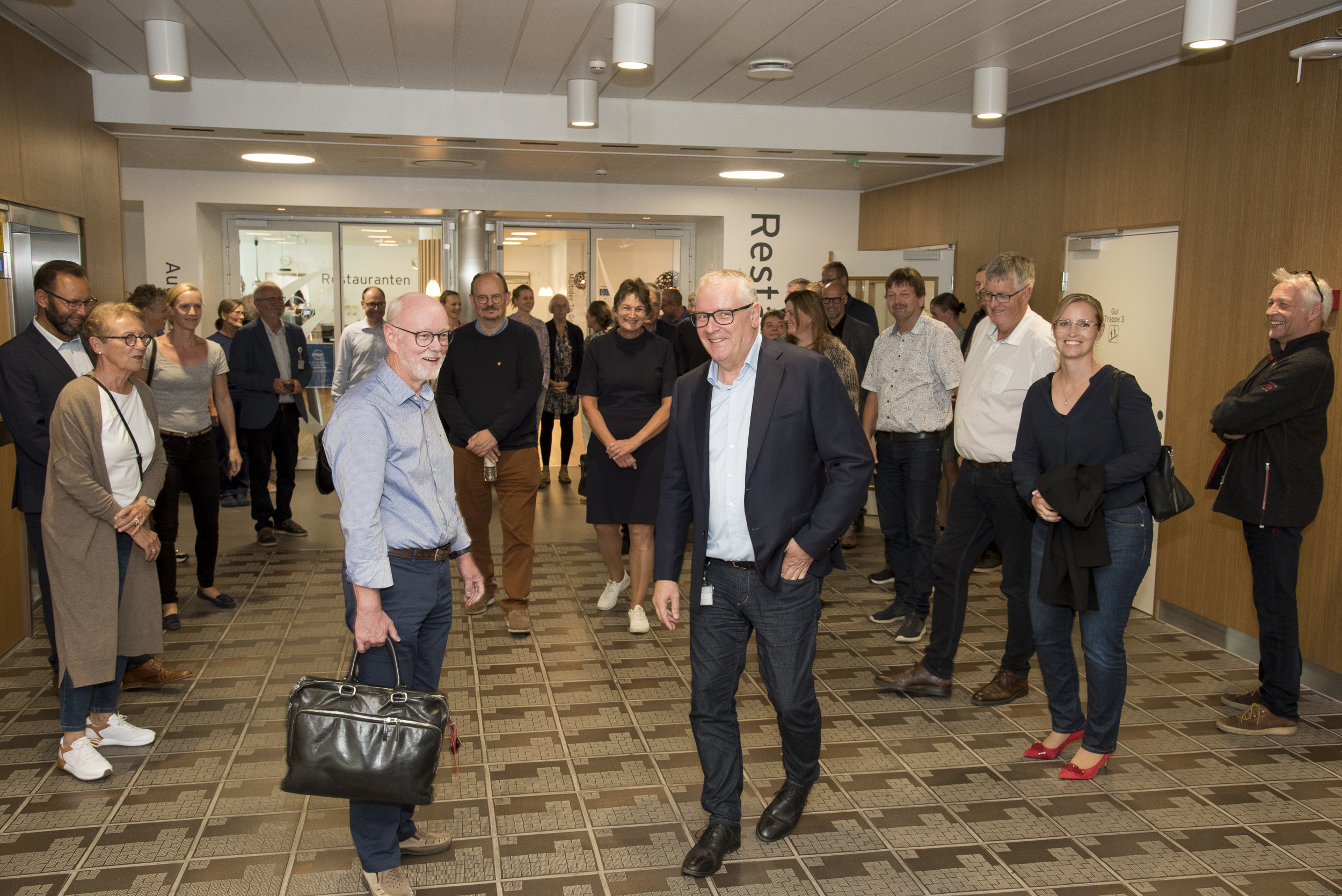 Der er god stemning blandt gæsterne, som står i sygehusets forhal.