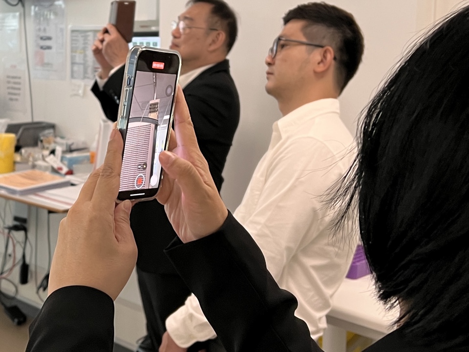 En deltager fra delegationen videofilmer i laboratoriet