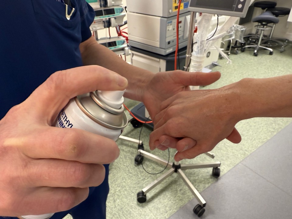 Sådan foregår det, når en patient får kuldespray på hånden, inden droppet lægges.