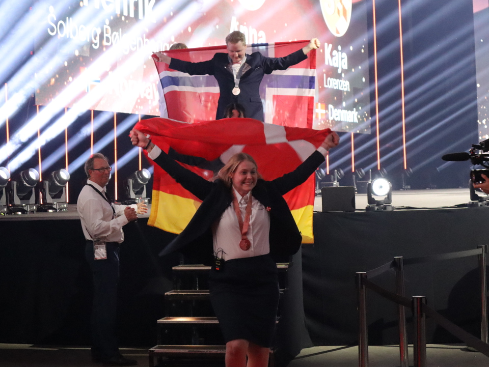 Kaja løber ned fra scenen med flaget om armene