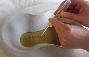 Opsugningsenheden placeres med spidsen i urinen i plastbægeret eller bækkenet.